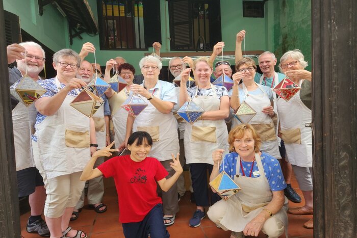 Les touristes apprennent à fabriquer des lanternes comme souvenir à Reaching Out Arts & Crafts